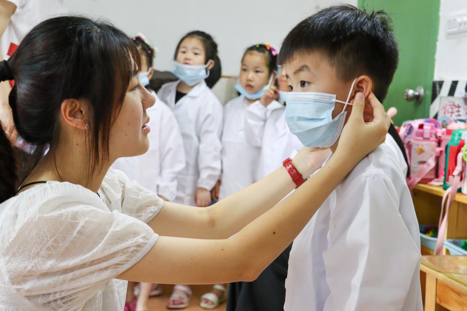 实践队员为小朋友戴好口罩.jpg