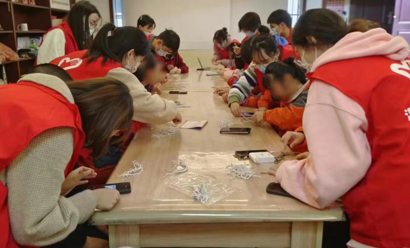 志愿者与居民做手绳中1.jpg