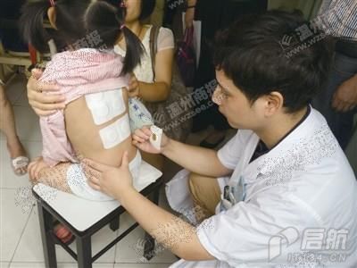 中医师吴龙溪为五岁的患儿贴敷治疗